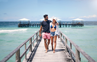 Image showing Couple smile, walking and travel on a tropical island on vacation with freedom by sea. Ocean, beach and deck walk of a man back and woman together with love in summer on a holiday outdoor in sun