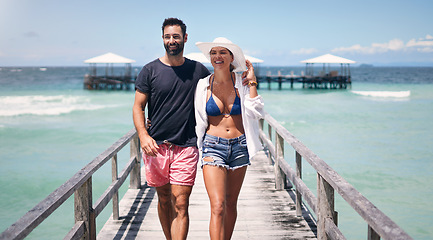 Image showing Beach, island and couple walking on deck for holiday, summer vacation and tropical weekend in Maldives. Love, travel and happy man and woman on luxury resort for honeymoon, anniversary and adventure