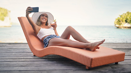 Image showing Selfie, travel and woman with water, summer and happiness on a sun lounger, cocktail and tropical island. Female person, girl or happy tourist on a break, social media and drink to relax and cheerful