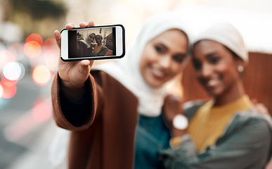 Image showing Muslim woman, friends and selfie with phone in city for travel, urban adventure or post for social media app. Islamic women, smartphone photography and profile picture on internet, web or blog in cbd