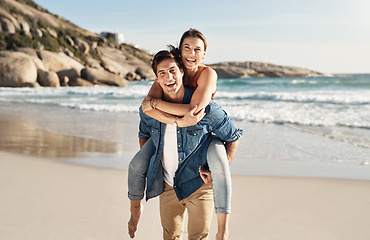 Image showing Couple, portrait and piggyback with smile at beach in summer sunshine for love, romance and bond for travel. Man, woman and happy with hug, ocean waves and trust in nature, outdoor and sea holiday