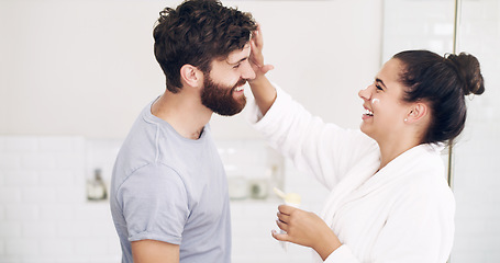 Image showing Couple, face skincare cream and bathroom with smile, helping hand and morning together in home. Woman, man and skin wellness for help, care or laughing with product for lifestyle, beauty or health