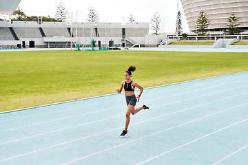 Image showing Woman, fitness and running on stadium track for exercise, cardio training or workout outdoors. Fit, active or sporty female person athlete or runner in sports run, athletics or healthy wellness