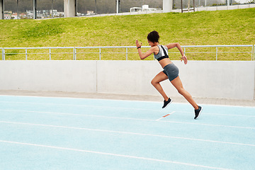 Image showing Woman, fitness and running on track for cardio training, exercise or workout on the stadium. Active or sporty female person, athlete or runner in sports run, race or competition for healthy wellness