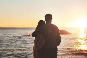 Image showing Sunset, beach and couple hug by ocean in evening on holiday, summer vacation and weekend. Nature, love and man and woman embrace, hugging and relax for bonding, quality time and peace in evening