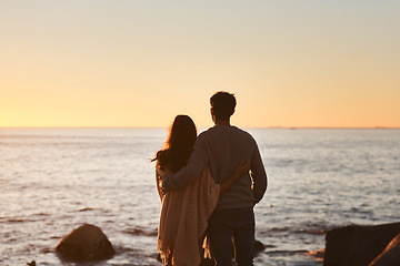 Image showing Hug, sunset and couple relax on beach in evening on holiday, summer vacation and weekend by ocean. Nature, love and man and woman embrace, hugging and calm for bonding, quality time and peace by sea