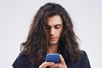 Image showing Phone, communication and face of man in studio typing for social media post, internet and online chat. Mockup, white background and male person on smartphone for website, mobile app and networking