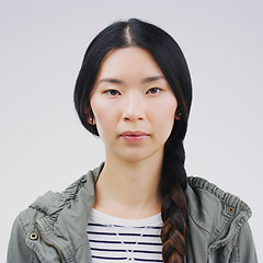 Image showing Face, serious portrait and asian woman in studio with concentration and focus. Headshot of a young female student or natural model from Japan with casual clothes isolated on a white background