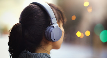 Image showing Woman with headphones in city, back view and listening to music, bokeh and technology outdoor. Mockup space, podcast or radio streaming with female person in urban street and audio playlist