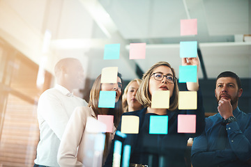 Image showing Business people, brainstorming and collaboration on glass for schedule, calendar and planning goals. Woman, manager and mentor of ideas at window for sticky note feedback, agenda and timeline