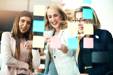 Image showing Business women, brainstorming and planning schedule of target, team goals and agenda at window. Happy employees, diversity and sticky note for timeline of workflow process, calendar and project ideas