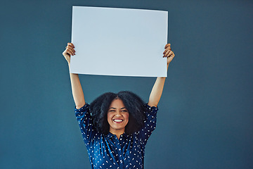 Image showing Poster, mockup and portrait of happy woman in studio with banner for news, social media or advertising on blue background. Space, sign and female smile with paper, board and branding promotion