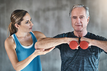 Image showing Helping, dumbbell and fitness with old man and personal trainer for support, health and physiotherapy. Training, weightlifting and coaching with senior patient and female trainer for elderly workout