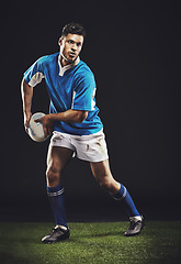 Image showing Rugby, passing and man athlete running in dark studio background while training, wellness and fitness sport. Exercise, workout and professional career of sports male person or player on grass