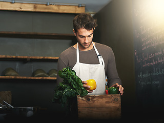 Image showing Man, market and owner with vegetables or groceries in a bag for cooking or chef in the kitchen and at a supermarket. Male, shopkeeper and sorting healthy food dinner or packaging box of ingredients