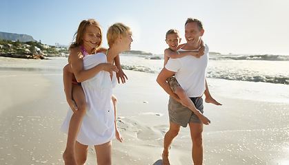 Image showing Beach, family walk and piggyback with laughing mother, father and kids together outdoor in nature travel. Sea, smile or happiness with bonding, parent support and love walking by the ocean on holiday