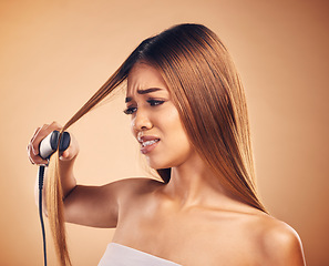 Image showing Woman with flat iron, hair care fail and worried about heat damage with hairloss isolated on studio background. Electric straightener, female model with anxiety about keratin treatment and hairstyle