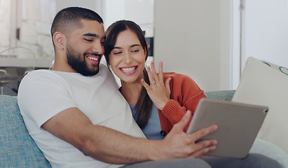 Image showing Engagement, announcement and a couple on a video call from a sofa in the living room of their home together. Smile, proud or excited with a happy man and woman sharing good news about their marriage