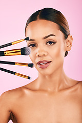 Image showing Woman, portrait and makeup brushes for beauty cosmetics against a pink studio background. Isolated female person or model with cosmetic tools or equipment for grooming, products or facial treatment
