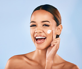 Image showing Happy woman, face and portrait with skincare cream for beauty moisturizer against a blue studio background. Female person or model with smile in happiness for facial lotion, cosmetics or products