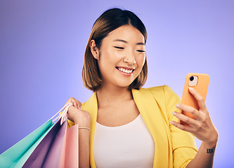 Image showing Asian woman, selfie and shopping bag in studio with smile for deal, sale or discount by backdrop. Japanese influencer girl, retail and happy with social media, contact and luxury by purple background