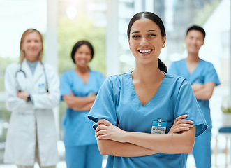 Image showing Portrait, medical and a woman nurse arms crossed, standing with her team in the hospital for healthcare. Leadership, medicine and teamwork with a female health professional in a clinic for treatment