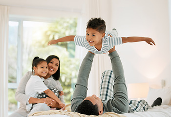 Image showing Airplane, family and father with boy, bed and happiness with bonding, loving together and laughing. Love, parents and siblings in a bedroom, brother and sister playing games, fun and weekend break