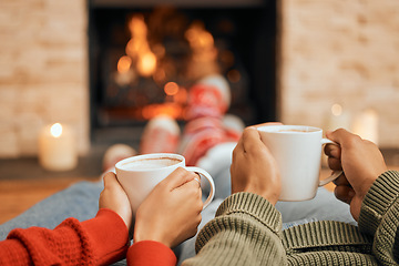 Image showing Hands, coffee and couple relax by fireplace, bonding and cozy in home together. Tea, man and woman relaxing by fire on Christmas holiday in winter, heat and enjoying quality time with drinks in house