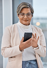 Image showing Mature woman, phone and typing in office, checking email or social media for business website. Cellphone, scroll and businesswoman ceo surfing internet for networking, search and reading online post.