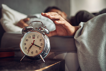 Image showing Alarm clock, wake up and man sleeping in the bedroom of his modern apartment in the morning. Lazy, resting and hand of male person taking a nap and dreaming in bed with time watch at his home.