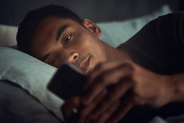 Image showing Night, scroll and man in bed with phone surfing internet, social media post or texting with insomnia in home. Wake up, browse and male in dark bedroom with cellphone, mobile game and digital app.