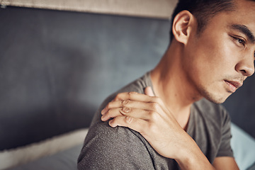 Image showing Stress, sick and man with shoulder pain in his bedroom in recovery from an accident or injury. Illness, medical emergency and male person holding a sprain back muscle while resting in his apartment.