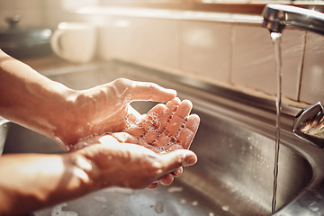 Image showing Soap, water and cleaning hands in kitchen for hygiene, health and wellness in home to clean skin. Tap, sink and skincare, hand wash with cleansing foam and bubbles for germ and bacteria protection.