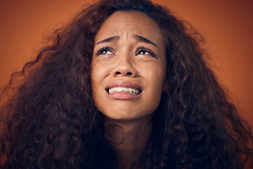 Image showing Woman, crying and sad face in studio with anxiety, mental health problem and depression. Headshot of african female person on a brown background for cry emoji, psychology and broken heart with tears