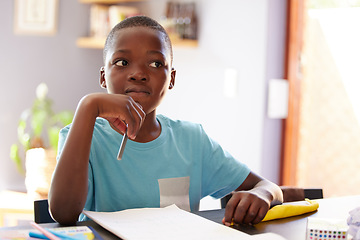 Image showing Education, thinking and boy child doing homework with his knowledge notebook in the living room. School, paper and African kid student studying for test, project or exam with concentration at home.