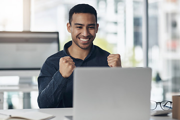 Image showing Young business man, celebration and laptop with smile, winning or success on stock market in office. Indian businessman, computer and winner fist to celebrate profit, bonus or online gambling at desk