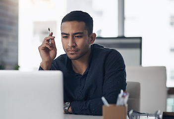 Image showing Laptop, thinking and reading with a man journalist working in his office for editing a news report or article. Computer, idea and online with a young male editor at work in a modern journalism agency