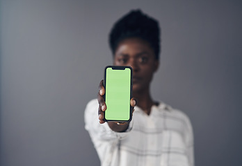 Image showing Green screen, phone and woman in portrait isolated on a studio background for advertising space or mockup. Online mock up, show and african person with social media, networking or marketing design
