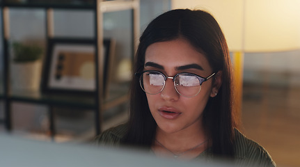 Image showing Computer, night and professional with a woman editor working in an office at night for a journalism report. Face, editing and focus with a young journalist at work on a desktop for online content