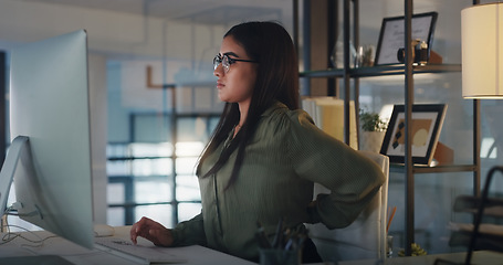 Image showing Business woman, back pain and computer at night in office with stress, burnout or crisis. Female entrepreneur at a desk with tech, fatigue and backache while tired of deadline or internet problem