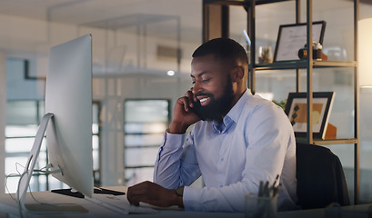 Image showing Business man, phone call and computer at night while working at a desk for communication and crm. Black male entrepreneur with a smartphone for networking, connection and conversation with a contact