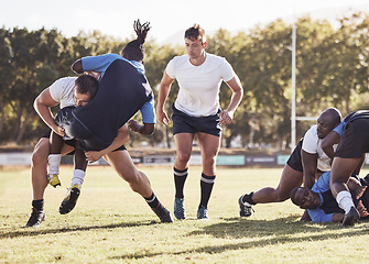 Image showing Rugby, sports and men tackle for ball on field for match, practice and game in tournament or competition. Fitness, teamwork and players playing on grass for exercise, training and performance to win