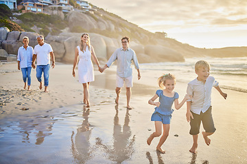 Image showing Family, generations and kids with running, beach and sunset with men, women and happiness with love. Parents, grandparents and children by ocean, holding hands or bond on summer vacation with smile