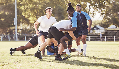 Image showing Fitness, rugby and men in tackle on field for match, practice and game in tournament or competition. Sports, teamwork and group of players playing for exercise, training and performance to win ball