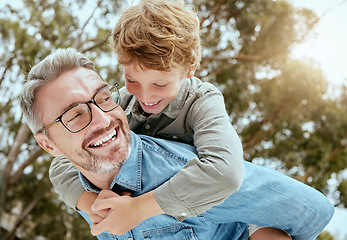 Image showing Piggyback, fun and father with child in a park happy, playing and having fun in nature. Hug, love and parent carrying son in a garden, laughing and enjoying games, smile and together on the weekend