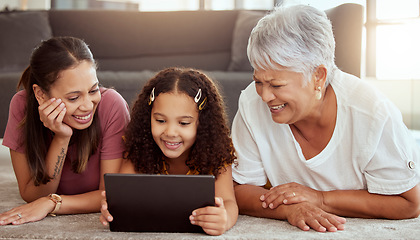 Image showing Mother, girl and grandmother with tablet, floor and happy for meme, movie or social media app in living room. Mama, kid and senior woman with touchscreen with smile, reading or learning on internet