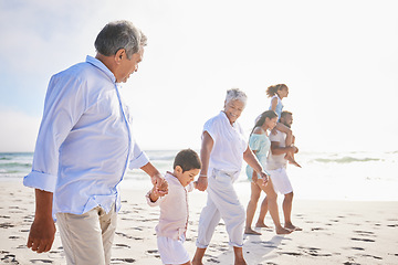 Image showing Big family, vacation and holding hands walking on beach for fun bonding, holiday or weekend together in nature. Grandparents, parents and children on ocean walk by the coast on mockup space outdoors