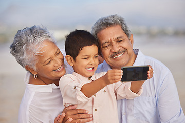 Image showing Selfie, smile and grandparents with child at beach for vacation, bonding and generations. Picture, happy and young boy with senior man and woman in nature for travel, happiness and technology