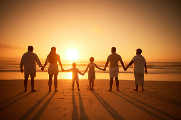 Image showing Family, holding hands beach at sunset and solidarity, grandparents travel with parents and kids with orange sky. Back, generations and men, women and children outdoor with silhouette and vacation