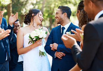 Image showing Wedding ceremony, couple and people clapping hands in celebration of love, romance and union. Happy, smile and bride with bouquet and groom walking by guests cheering for marriage at an outdoor event